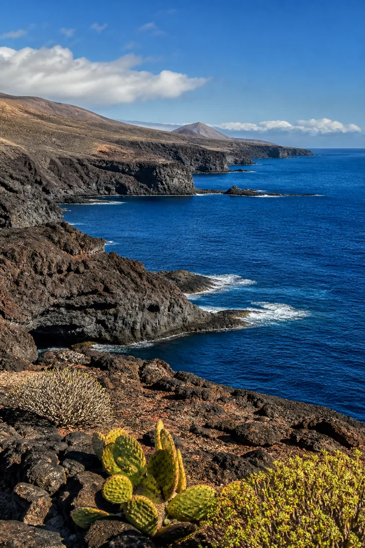 Schwarze Vulkanlandschaft an der tiefblauen Atlantikküste der Kanaren